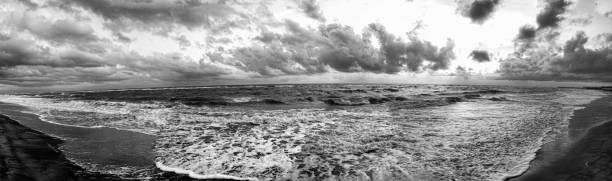 istock Dramatic awesome overcast sky and bad weather panorama above rough sea threatening waves crashing at the shore with lot of white foam 1284626577