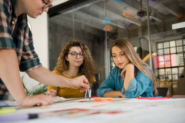 istock Group of designers drawing on a blueprint 1284627839