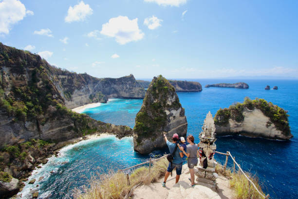 young parents and little kid enjoying the views in thousand islands viewpoint, on of the most amazing spots in nusa penida island, indonesia, bali - bali imagens e fotografias de stock