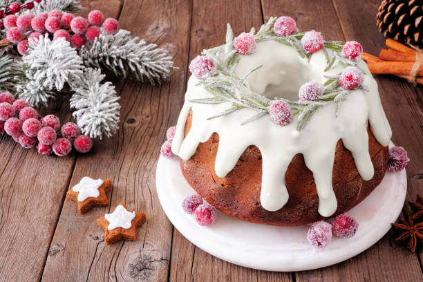 istock Christmas gingerbread cake with eggnog icing and wreath topping. Table scene with a rustic wood background. 1284630208