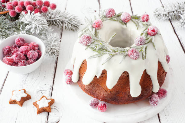 istock Christmas gingerbread cake with eggnog frosting and wreath topping. Table scene with a white wood background. 1284630822