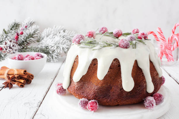 istock Christmas gingerbread cake with eggnog icing and wreath topping. Table scene with a bright background. 1284631143