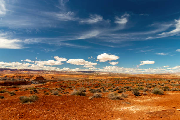 suelo rojo oscuro y arena del desierto con hermosos cielos y nubes cerca de page, az - small town america flash fotografías e imágenes de stock