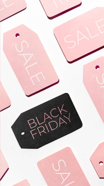 istock Top view on pattern of many pink and one black clothes tags on white background. Glamorous labels. Symbol of Black Friday sale and shopping. Flat lay. 1284634905