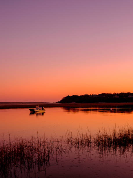 sunset silhouette seascape con moored boat en la bahía tranquila - cape cod new england sea marsh fotografías e imágenes de stock