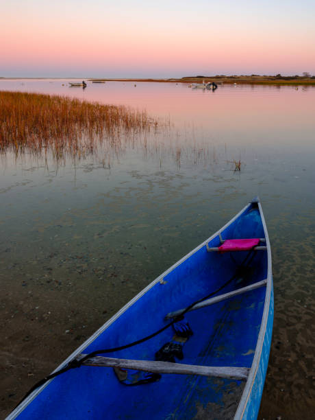 istock Tall Twilight Seascape with Pointed Blue Canoe on the Island Beach 1284640176