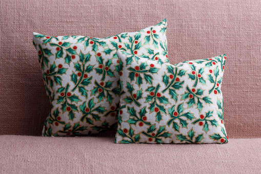 Two holiday pillows wth holly pattern