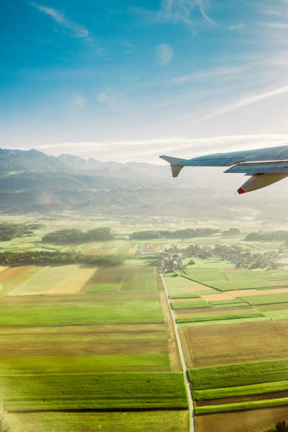istock airplane flying over land in the sun 1284649560