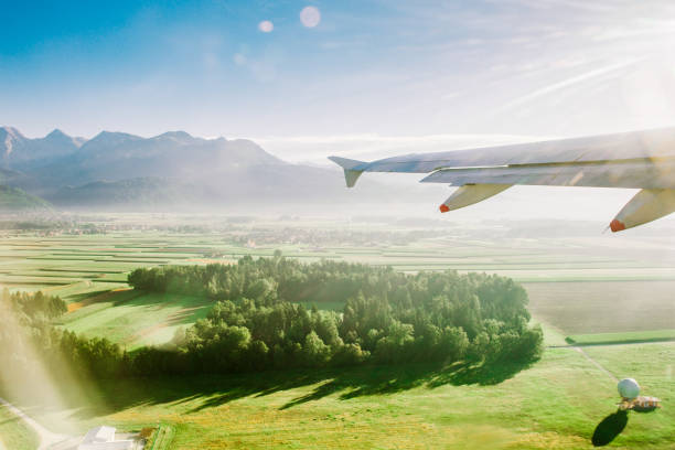 airplane flying over land in the sun