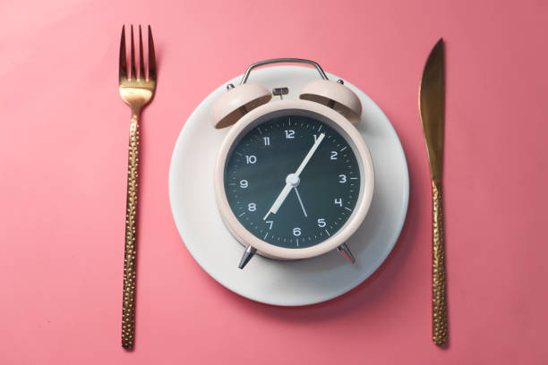 istock Alarm clock on plate on wooden table, top view. 1284656201