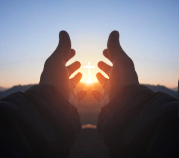 istock Religious concept: hands palm praying to cross in the sky 1284665272