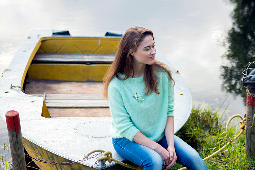 Young woman in green sweater posing in nature