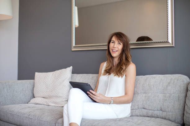 istock A beautiful woman using a digital tablet on the sofa at home. 1284673849