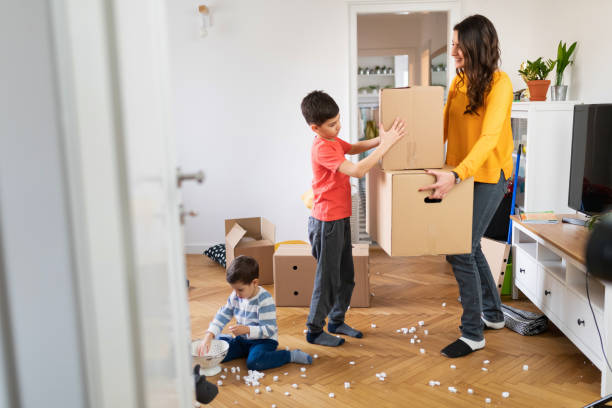istock Boy taking one box from his mother to help her during house move 1284675855
