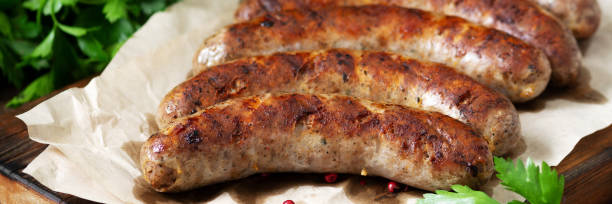 Fried sausages. Grilled sausages with spices on a wooden serving Board. Delicious meat sausages. Banner Fried sausages. Grilled sausages with spices on a wooden serving Board. Delicious meat sausages. Banner turkish sausage stock pictures, royalty-free photos & images
