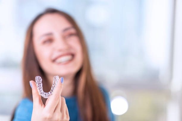 Invisaligner with model Beautiful smiling Turkish woman is holding an invisalign bracer, includes copy space Mouth Guard stock pictures, royalty-free photos & images