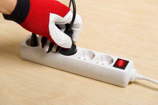 istock Closeup of an electrician plugging extension cords into each other. Mans hand plugging extension cord 1284678038