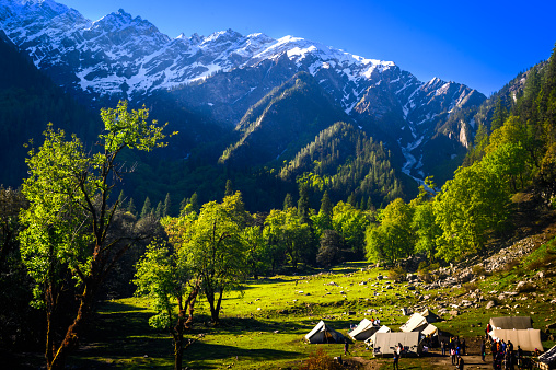 Mountain landscape with green grass, meadows scenic camping Himalayas peaks & alpine from the trail of Sar Pass trek Himalayan region of Kasol, Himachal Pradesh, India.