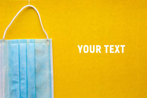 istock Medical mask on a yellow background. Copy space, concept 1284680987