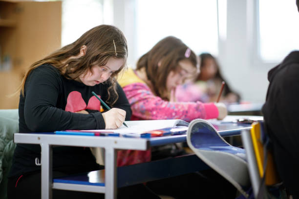 istock Teenager with down syndrome coloring at class 1284680997