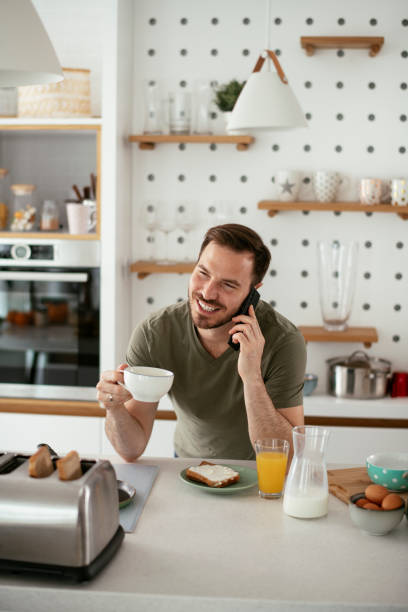 istock Young man drinking coffee and talking to the phone. 1284682996