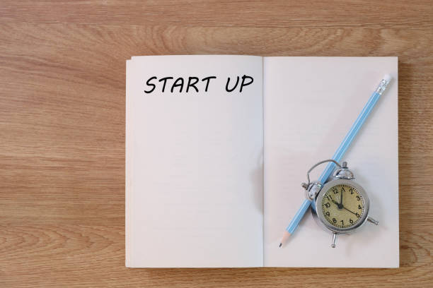 istock Start up concept on notebook with pencil and clock on wooden table. Business concept. 1284684097