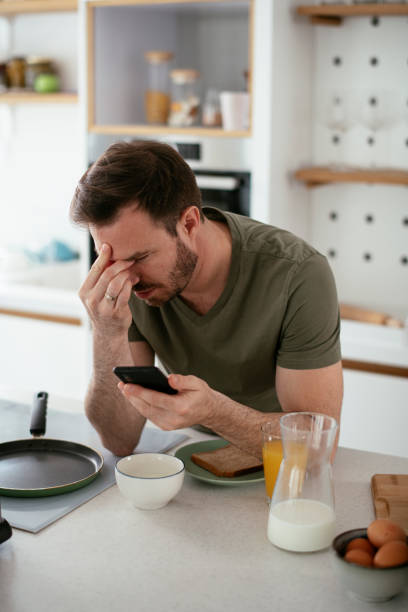 istock Young man eating breakfast and reading the news online. 1284684507