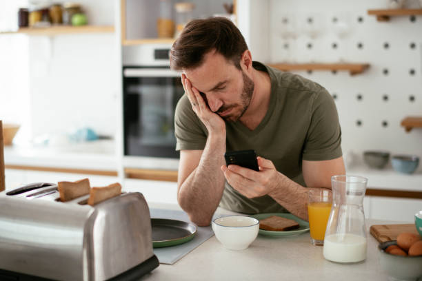 istock Young man eating breakfast and reading the news online. 1284684510