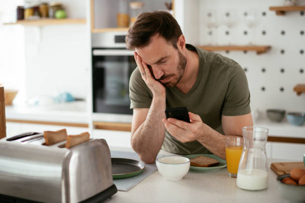 istock Young man eating breakfast and reading the news online. 1284685480