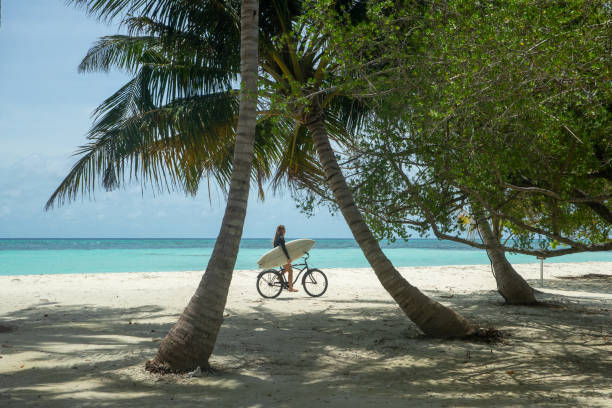 Surfer girl rides between two palms