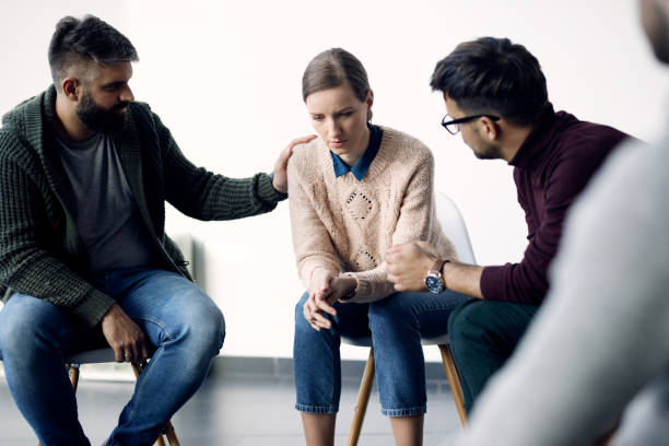 istock Young sad woman being consoled during group therapy counselling. 1284685710