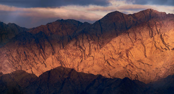 luz solar à noite iluminando montanhas vermelhas em israel. - red mountains - fotografias e filmes do acervo