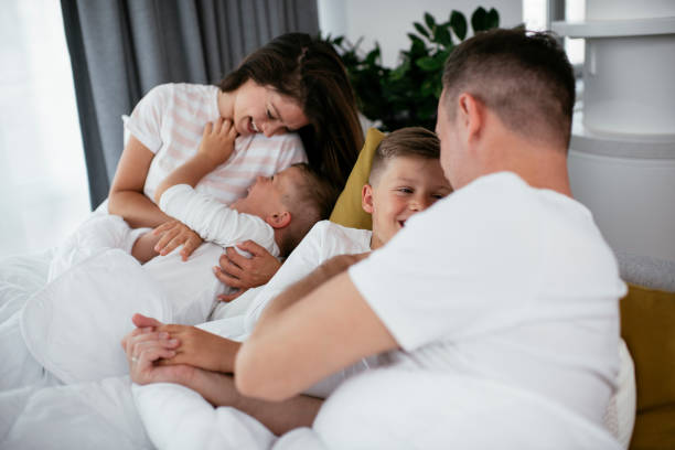 istock Happy parents with sons relaxing in bed. 1284688127