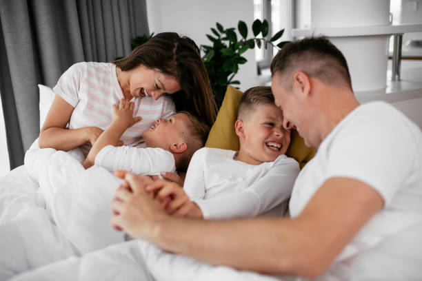 istock Happy parents with sons relaxing in bed. 1284688619