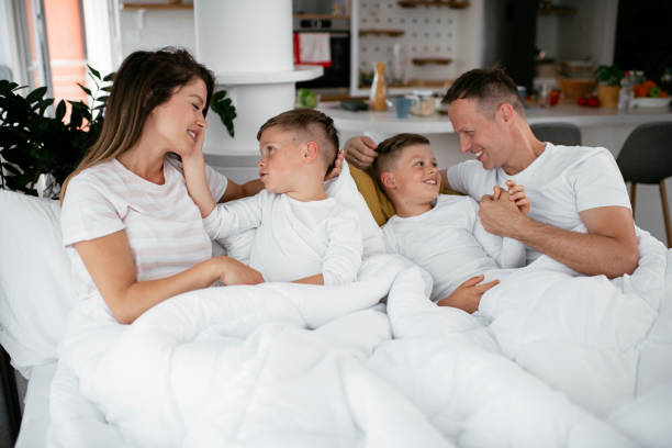istock Happy parents with sons relaxing in bed. 1284689140