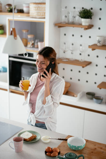 istock Beautiful woman preparing breakfast and using the phone. 1284690515