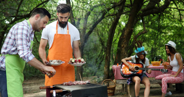 istock Friends making barbecue and having lunch in the nature 1284690740