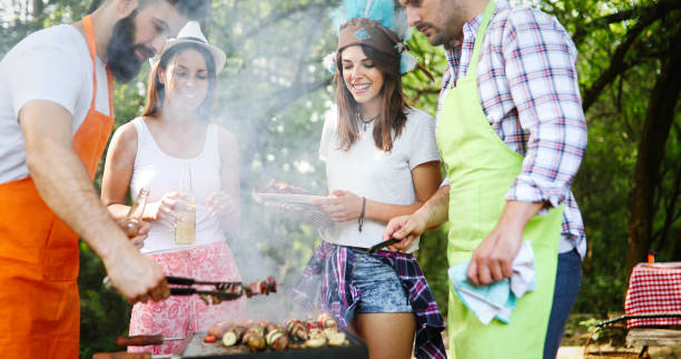 istock Friends making barbecue and having lunch in the nature 1284690755