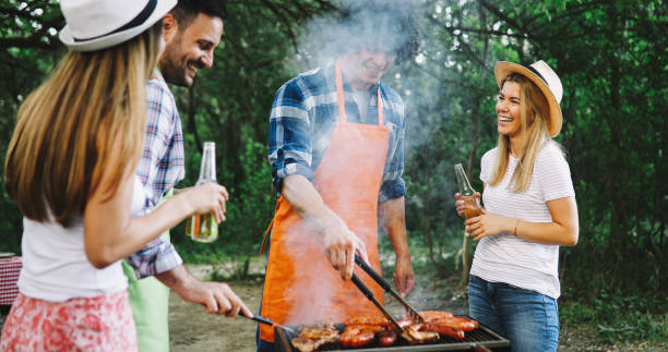 istock Friends making barbecue and having lunch in the nature 1284691285