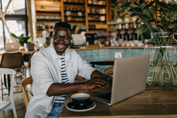 istock Young man sitting in coffee shop and working 1284693137