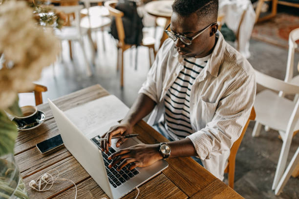 istock Young man sitting in coffee shop and working 1284693162