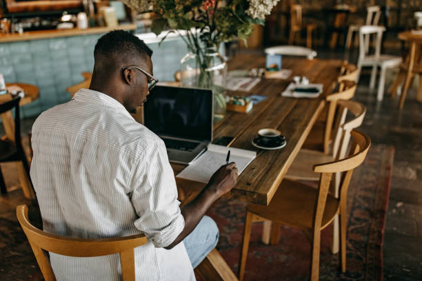 istock Young man sitting in coffee shop and working 1284693294