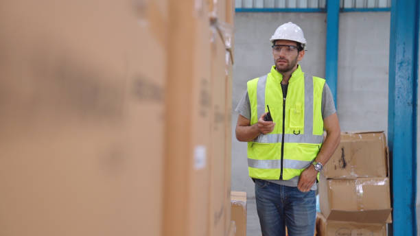 istock Professional cargo worker talks on portable radio to contact another worker 1284693397