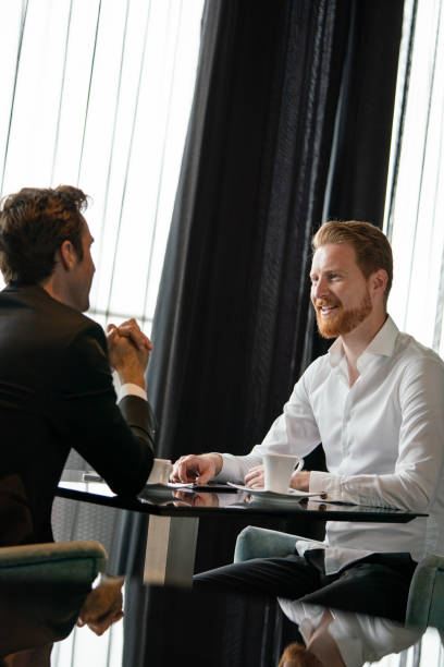 istock Coffee break. Two cheerful business men talking in a restaurant 1284694611