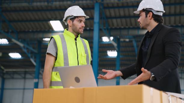 istock Two factory workers working and discussing manufacturing plan in the factory . 1284695244