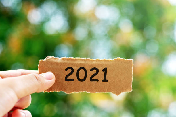 istock Hands Holding Torn paper With Number 2021 1284696254