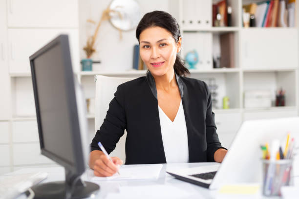 istock Young asian woman working in office and signs documents 1284696694