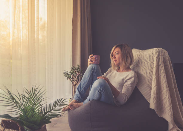 istock pensive woman drinking coffee at home 1284696770