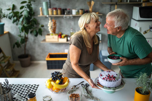 istock Senior couple having fun while decoration cake together in modern kitchen 1284699774