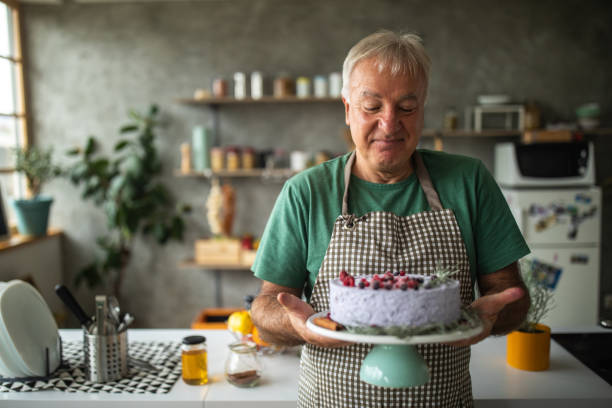 istock Senior man holding cake that he made in kitchen at home 1284700011